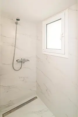 a shower in a white bathroom with a window at Altezza Terrazza Athens in Athens