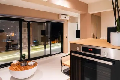 a living room with a large window and a kitchen at Aura Vista Acropolis view in Athens