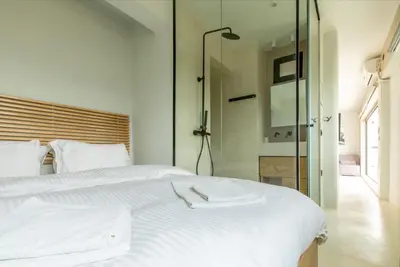 a bedroom with a white bed with a glass wall at Aura Vista Acropolis view in Athens