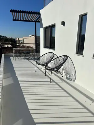two metal chairs sitting on the side of a building at Aura Vista Acropolis view in Athens