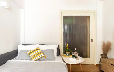 a bedroom with a bed with pillows and a table at Belita large 1BR close to the Acropolis in Athens