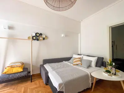 a bedroom with a bed and a table at Belita large 1BR close to the Acropolis in Athens