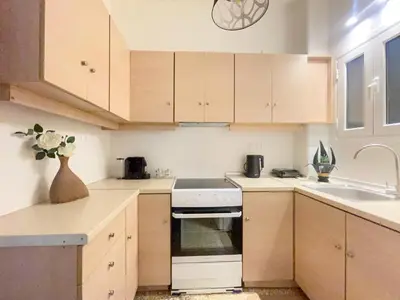 a kitchen with wooden cabinets and a stove top oven at Belita large 1BR close to the Acropolis in Athens