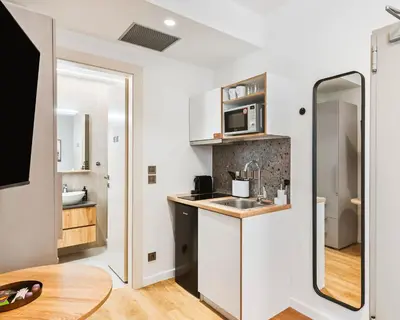 a small kitchen with a sink and a mirror at Limehome Piraeus Iris in Piraeus