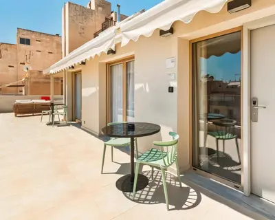 a patio with a table and chairs on a balcony at Limehome Piraeus Iris in Piraeus