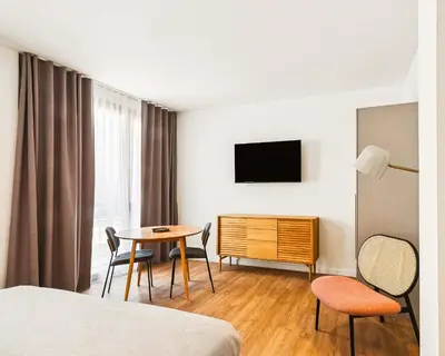 a hotel room with a table and chairs and a tv at Limehome Piraeus Iris in Piraeus