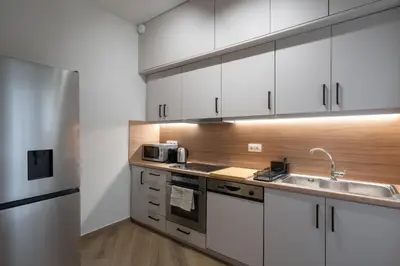 a kitchen with white cabinets and a sink at Acropolis Retreat Walk to Museum in Athens