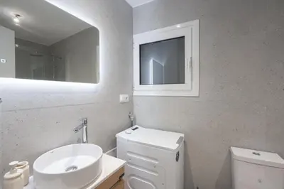 a bathroom with a sink and a toilet and a mirror at Acropolis Retreat Walk to Museum in Athens