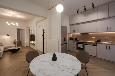 a kitchen and living room with a table and chairs at Acropolis Retreat Walk to Museum in Athens