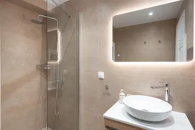a bathroom with a sink and a shower with a mirror at Acropolis Retreat Walk to Museum in Athens