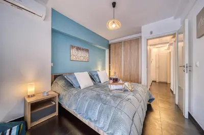a bedroom with a bed with a blue wall at Two bedroom Lux apartment Next to the metro in Athens