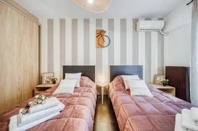 two beds in a room with striped walls at Two bedroom Lux apartment Next to the metro in Athens