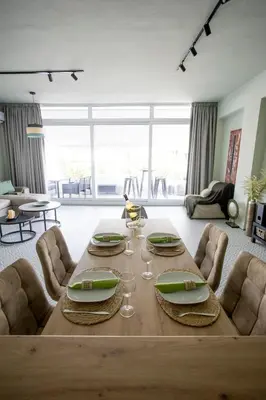 a living room with a wooden table with wine glasses at Acropolis Panorama Luxury Loft 8th fl Balcony View in Athens