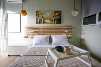a bedroom with a white bed and a table at Acropolis Panorama Luxury Loft 8th fl Balcony View in Athens