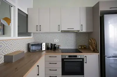 a kitchen with white cabinets and a stove top oven at Acropolis Panorama Luxury Loft 8th fl Balcony View in Athens