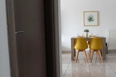 a dining room with a table and two yellow chairs at Stylish Apartment in Piraeus -F9 in Piraeus