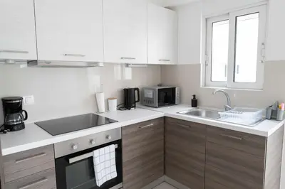a kitchen with white cabinets and a sink and a microwave at Stylish Apartment in Piraeus -F9 in Piraeus