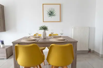 a dining room table with four yellow chairs at Stylish Apartment in Piraeus -F9 in Piraeus