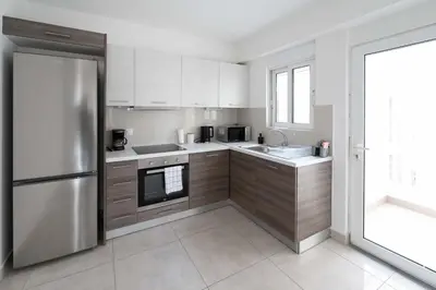 a kitchen with white cabinets and a stainless steel refrigerator at Stylish Apartment in Piraeus -F9 in Piraeus