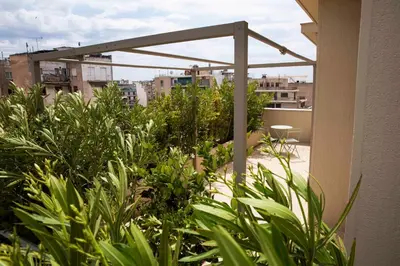 a balcony with green plants on a building at Contemporary Athenian Escape GHH in Athens