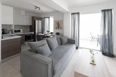 a living room with a gray couch and a kitchen at Top-Floor Retreat in Piraeus-H5 in Piraeus
