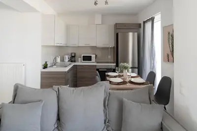 a living room with a couch and a table in a kitchen at Top-Floor Retreat in Piraeus-H5 in Piraeus