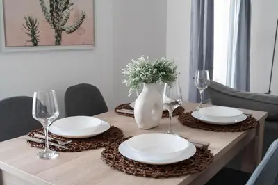 a table with plates and glasses and a vase with flowers at Top-Floor Retreat in Piraeus-H5 in Piraeus