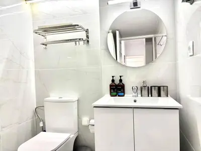 a white bathroom with a toilet and a mirror at Alimos Apartment near Edem Beach and the Sea with 2 Bedroom in Athens
