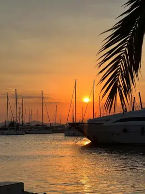 a group of boats in the water at sunset at Alimos Apartment near Edem Beach and the Sea with 2 Bedroom in Athens
