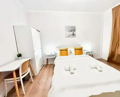 a white bedroom with two beds and a desk at Alimos Apartment near Edem Beach and the Sea with 2 Bedroom in Athens