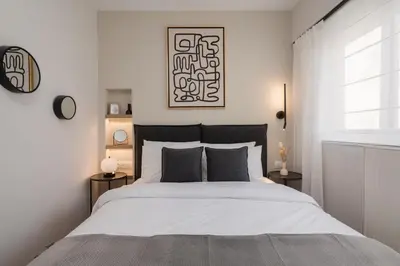 a white bedroom with a large bed and a window at Modern Apartment in Athens with Balcony in Athens