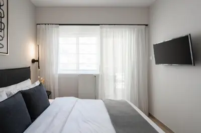 a bedroom with a bed and a television on a wall at Modern Apartment in Athens with Balcony in Athens