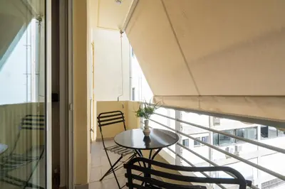 a room with a table and chairs and a balcony at Modern Apartment in Athens with Balcony in Athens