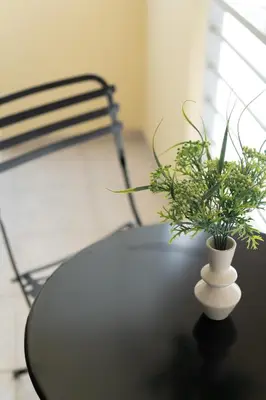 a white vase on a table with a plant at Modern Apartment in Athens with Balcony in Athens