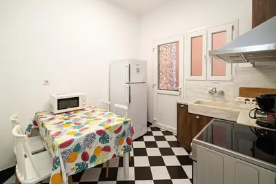 a kitchen with a table and a refrigerator at Acropolis Anemone Apartment in Athens