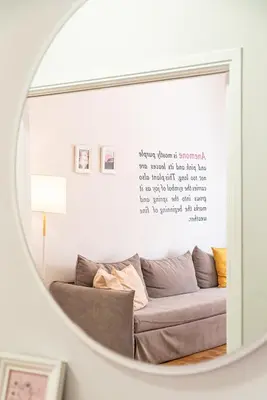 a mirror reflecting a couch in a living room at Acropolis Anemone Apartment in Athens
