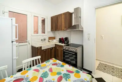 a kitchen with a table and a stove top oven at Acropolis Anemone Apartment in Athens
