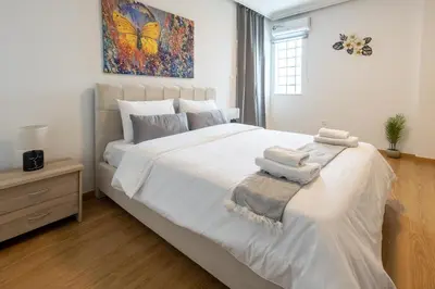 a bedroom with a large white bed with towels on it at Elegant Sea View Stay - Piraeus Port in Piraeus