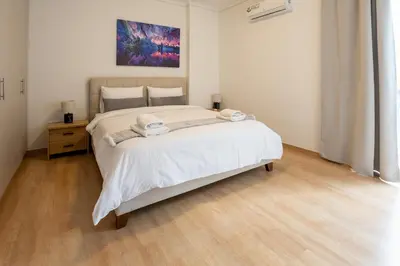 a bedroom with a large bed with two towels on it at Elegant Sea View Stay - Piraeus Port in Piraeus