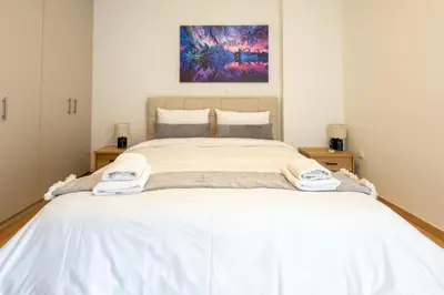 a bedroom with a large bed with white sheets at Elegant Sea View Stay - Piraeus Port in Piraeus