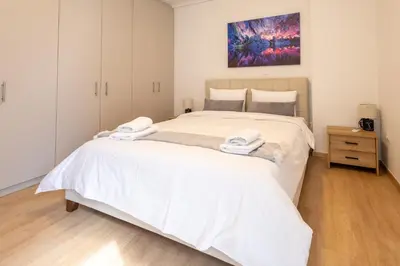 a bedroom with a large white bed with white sheets at Elegant Sea View Stay - Piraeus Port in Piraeus