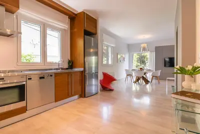 a kitchen with stainless steel appliances and a dining room at Cozy & Renovated, Walk to beach in Athens