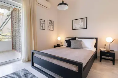 a bedroom with a bed with two lamps and a window at Cozy & Renovated, Walk to beach in Athens
