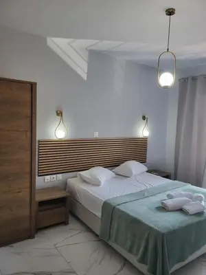 a bedroom with a large bed and two lights at Diamond Piraeus Port in Piraeus