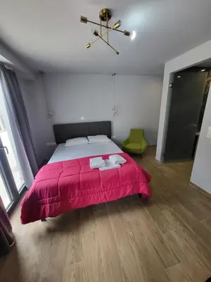 a bedroom with a large bed with a pink blanket at Diamond Piraeus Port in Piraeus