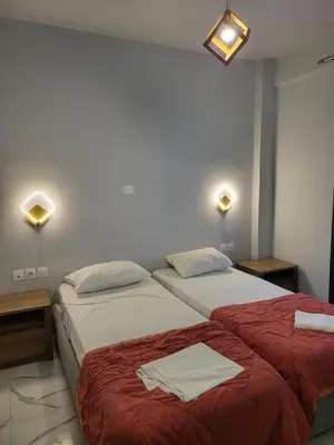 two beds in a room with lights on the wall at Diamond Piraeus Port in Piraeus