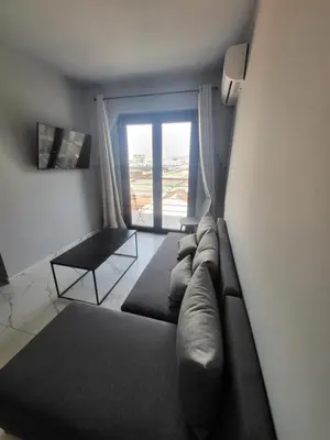 a living room with a couch and a large window at Diamond Piraeus Port in Piraeus