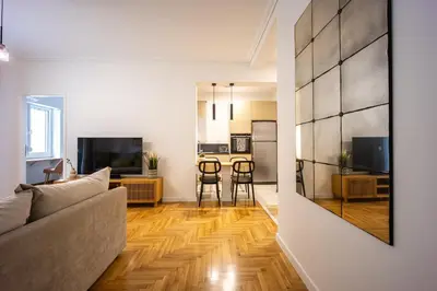 a living room with a couch and a kitchen at Attica Skyline Living! in Athens