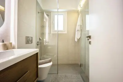 a bathroom with a toilet and a glass shower at Attica Skyline Living! in Athens