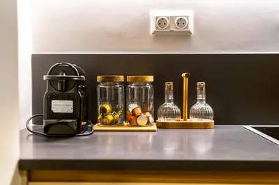 a kitchen counter with glass bottles on a counter top at Attica Skyline Living! in Athens